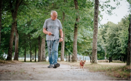 Homme promenant son chien au camping résidence la rivière de sainte cécile